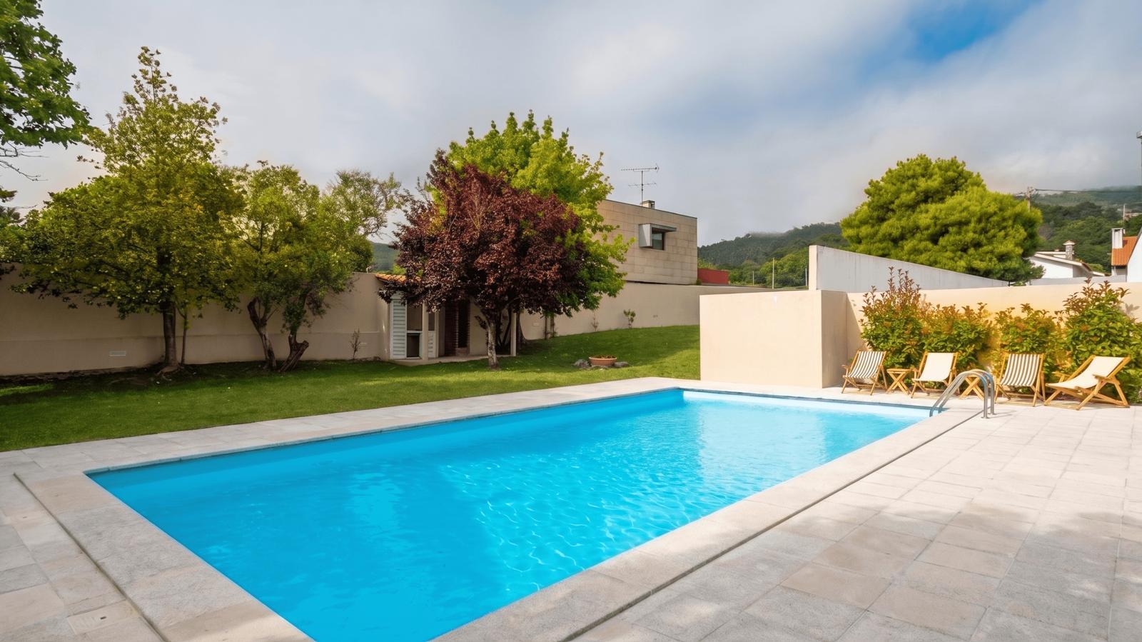 Piscina e jardim da casa com a serra ao fundo
